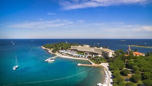 An aerial view of a coastal hotel with a pool, marina, and ocean views. - Maistra Select Island Hotel Istra (Rovinj)