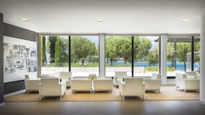 A modern waiting area with large windows, white chairs, and a minimalist design. - Maistra Select Island Hotel Istra (Rovinj)