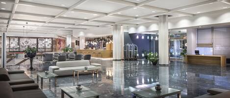 A spacious lobby with a reception desk, seating area, and a bar.