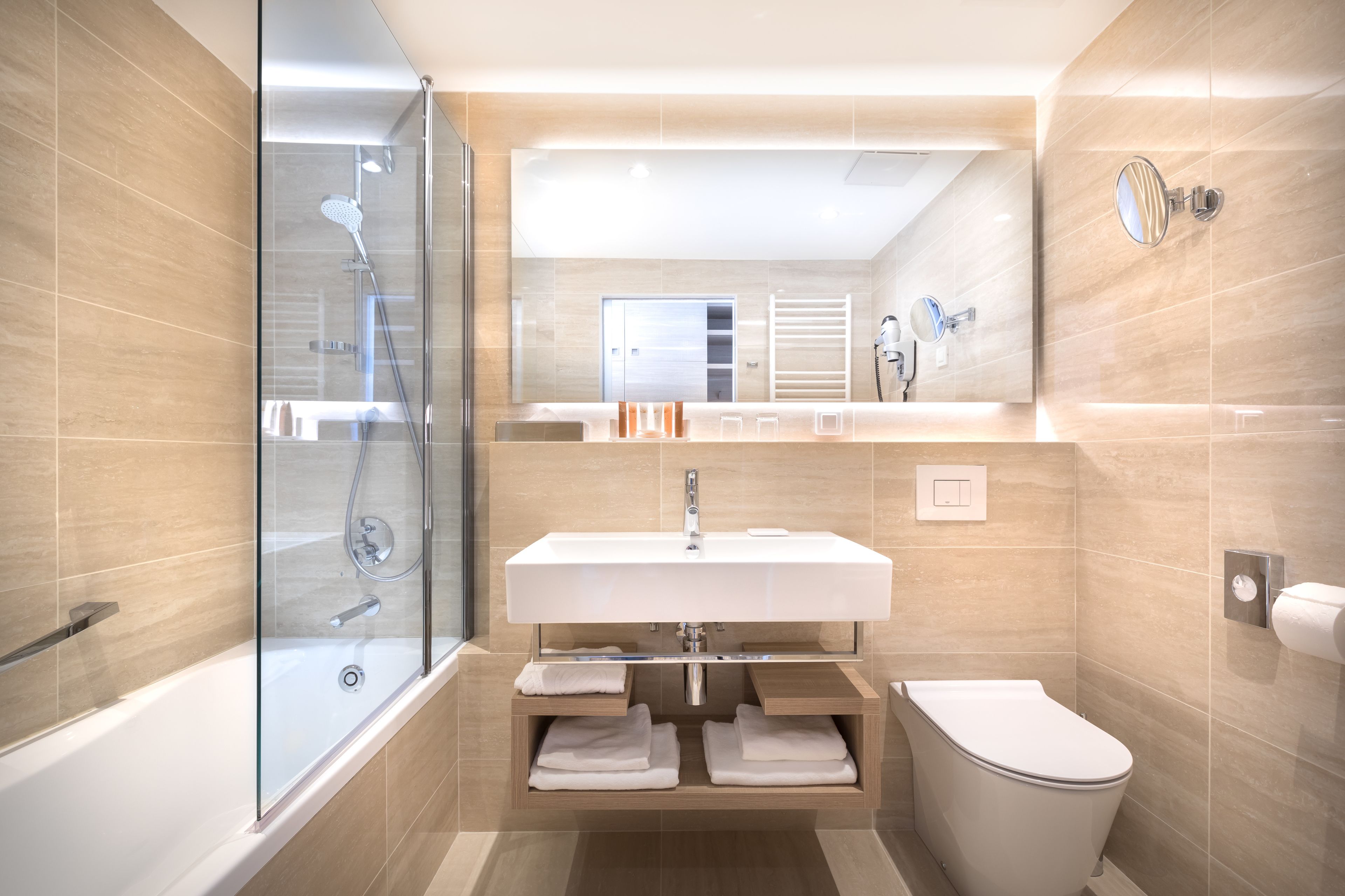 A modern bathroom with a glass-enclosed shower, a white sink, and a toilet.
