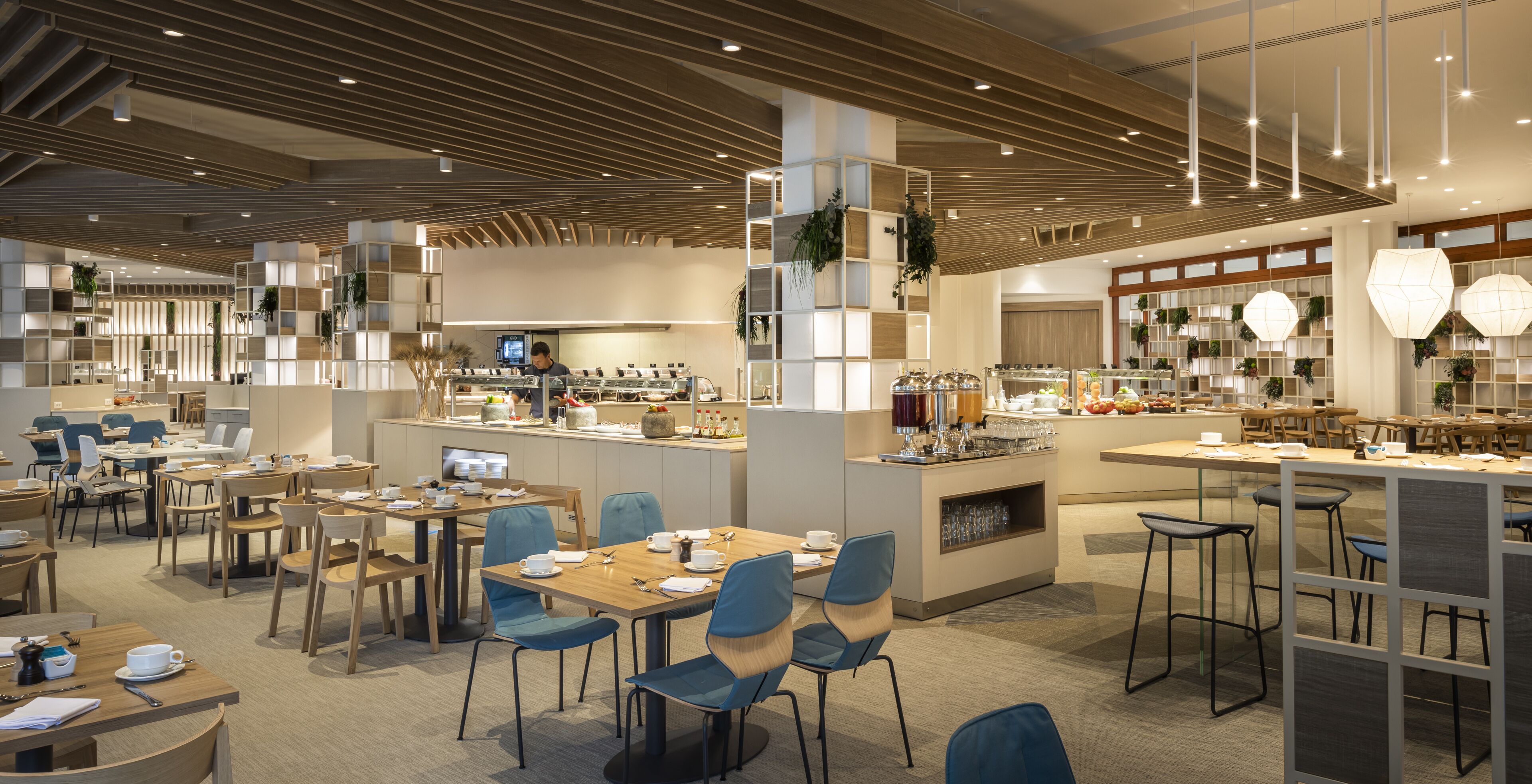 A modern restaurant with multiple dining areas, a central bar, and a variety of seating options.