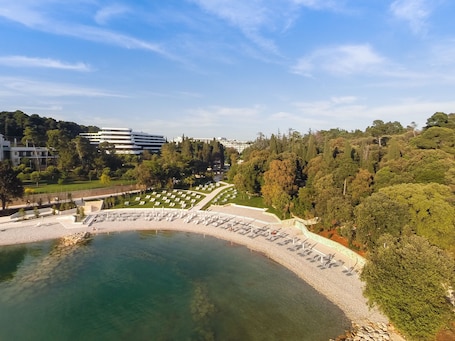 En la playa, sillas reclinables de playa, sombrillas. Eden Hotel by Maistra Collection
