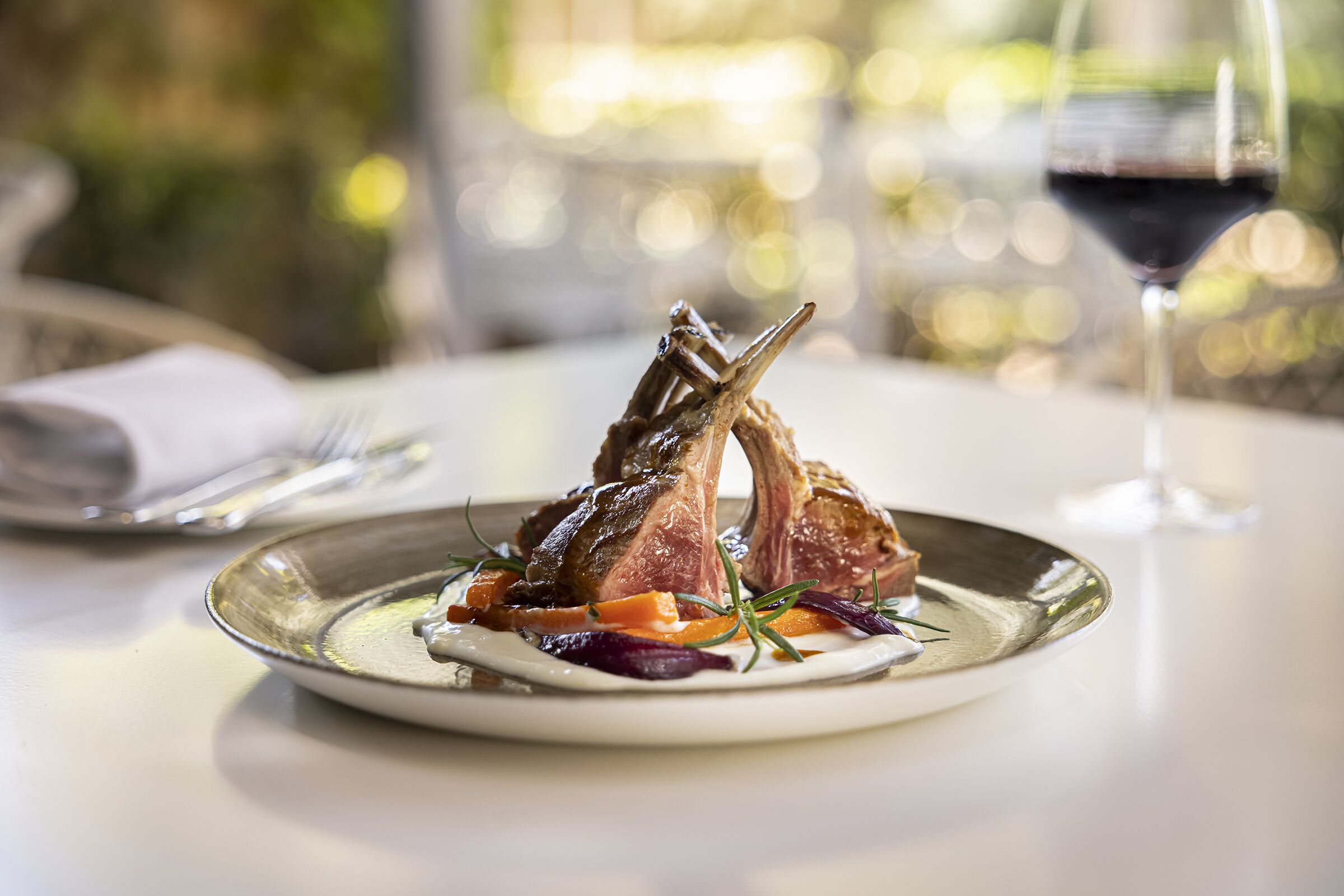 Ein Teller Essen mit einem Glas Rotwein auf einem Tisch.