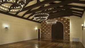 Ein geräumiges Zimmer mit Holzdielen, einer Ziegelwand und einem großen Bogenportal.