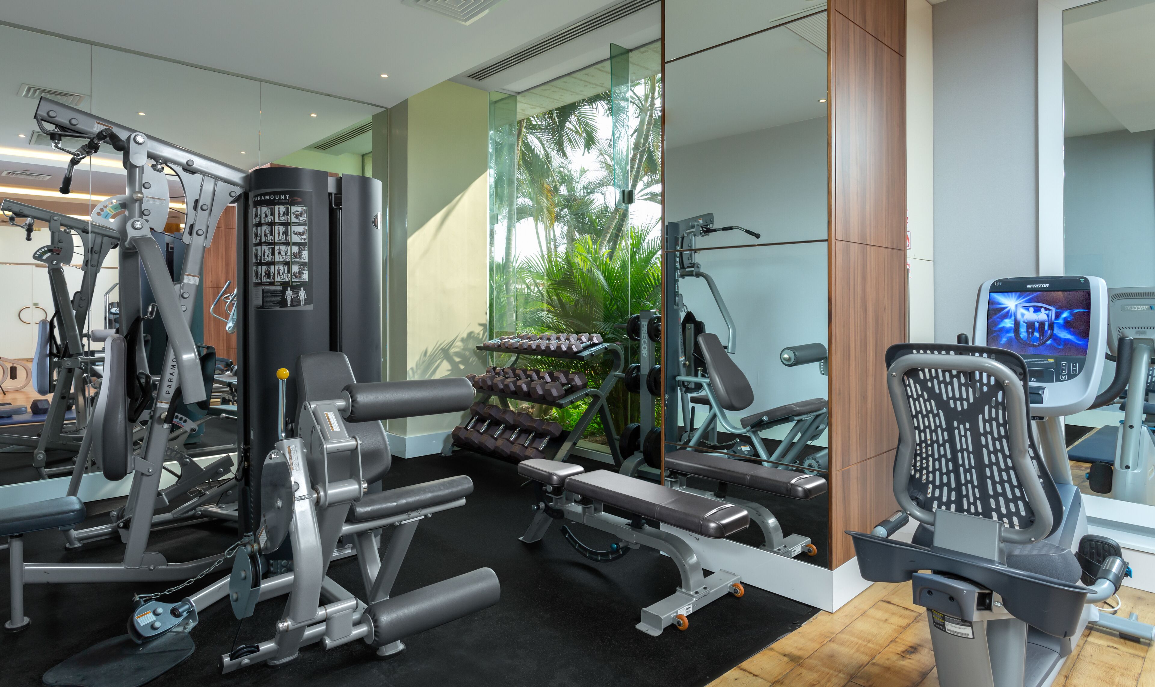 A modern gym with various exercise equipment, including weight machines, dumbbells, and a treadmill.