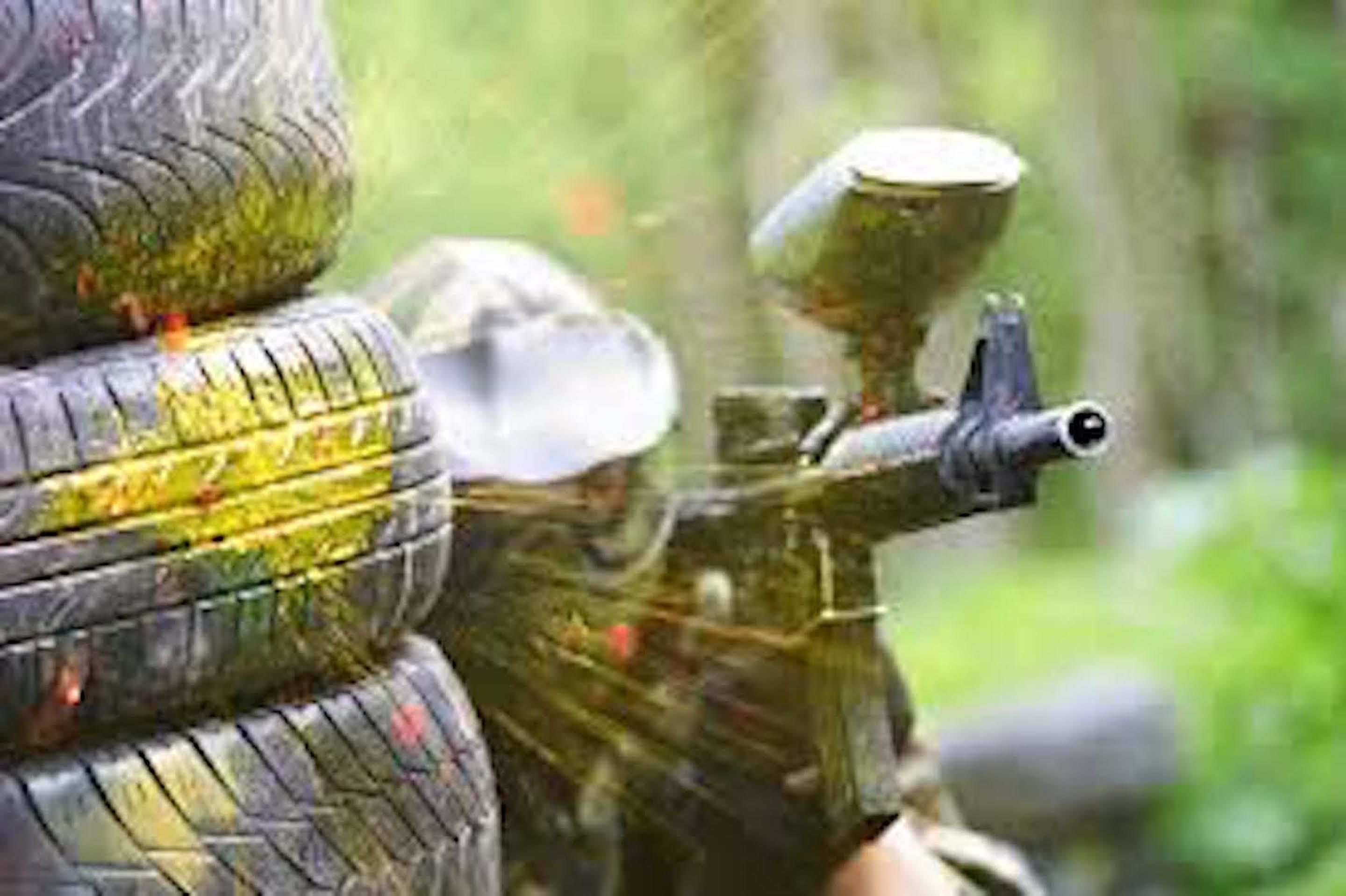 Ein Detailaufnahme eines Paintball-Gewehres mit einem Behälter voller Paintballs.