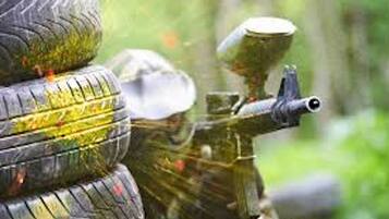 Ein Detailaufnahme eines Paintball-Gewehres mit einem Behälter voller Paintballs.