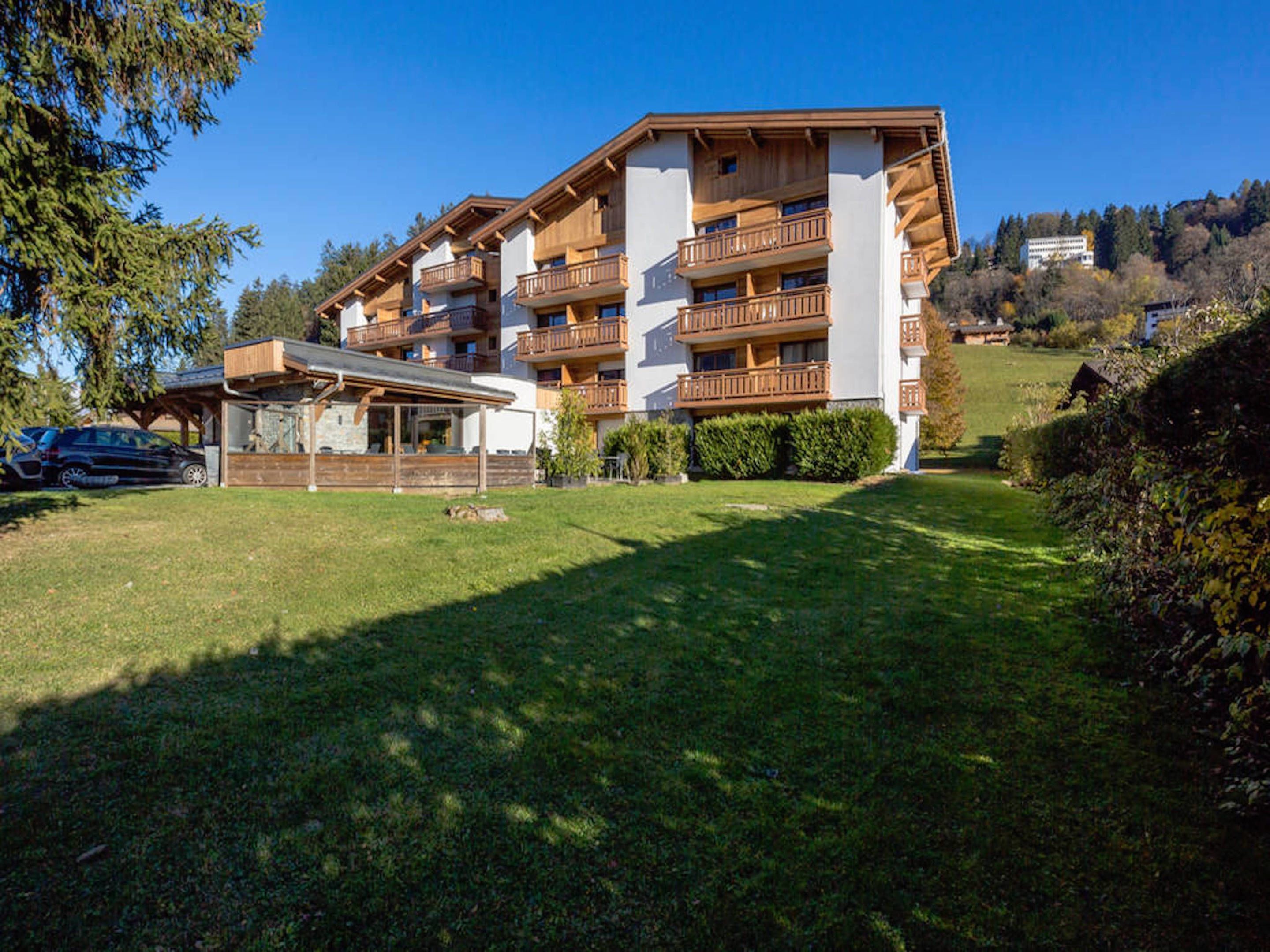 A multi-story hotel with wooden balconies and a covered outdoor seating area.