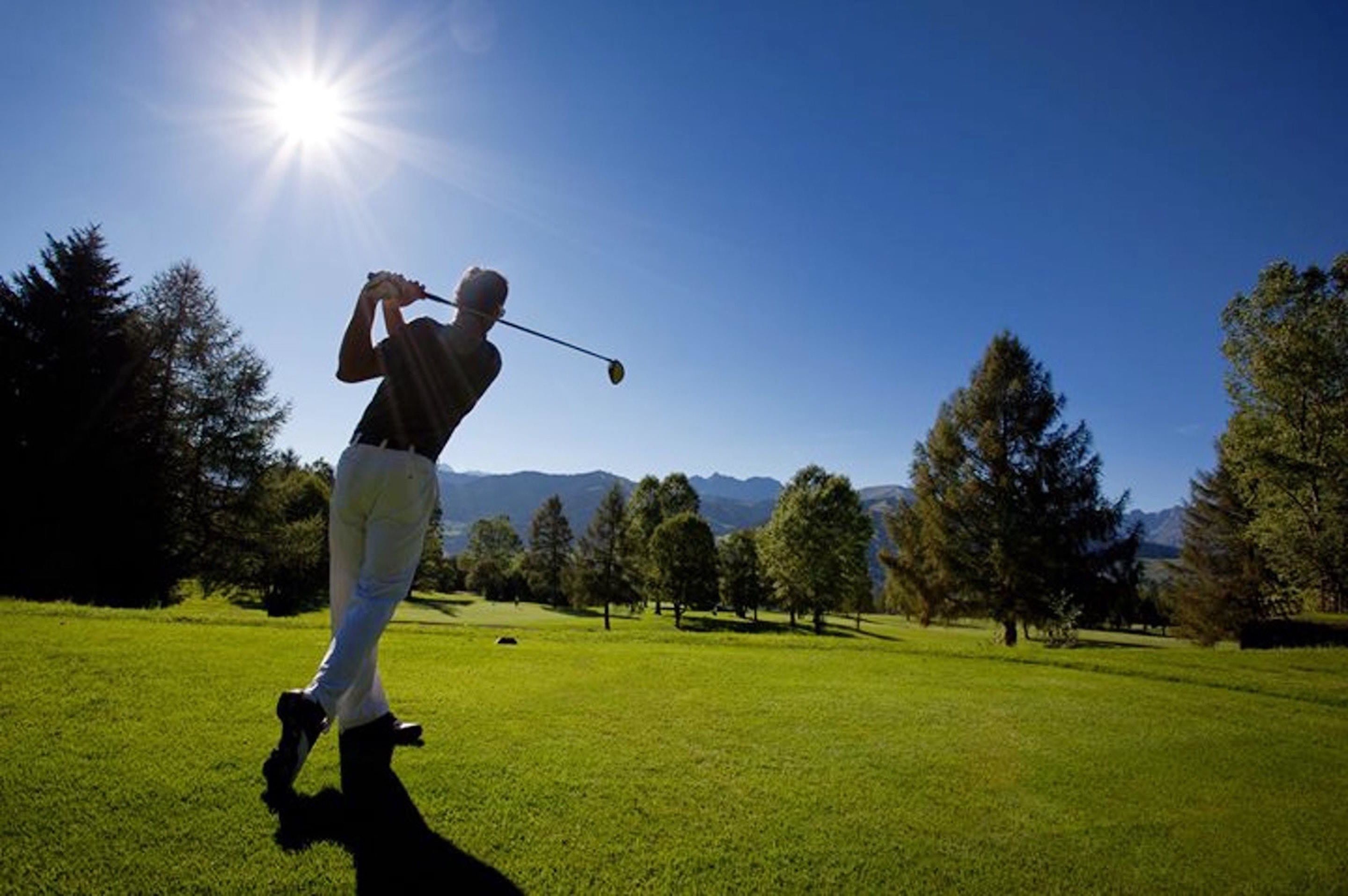 A person playing golf on a sunny day.
