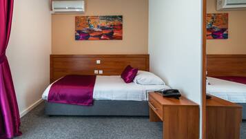 Quarto de hotel com uma cama, mesa de cabeceira e espelho.