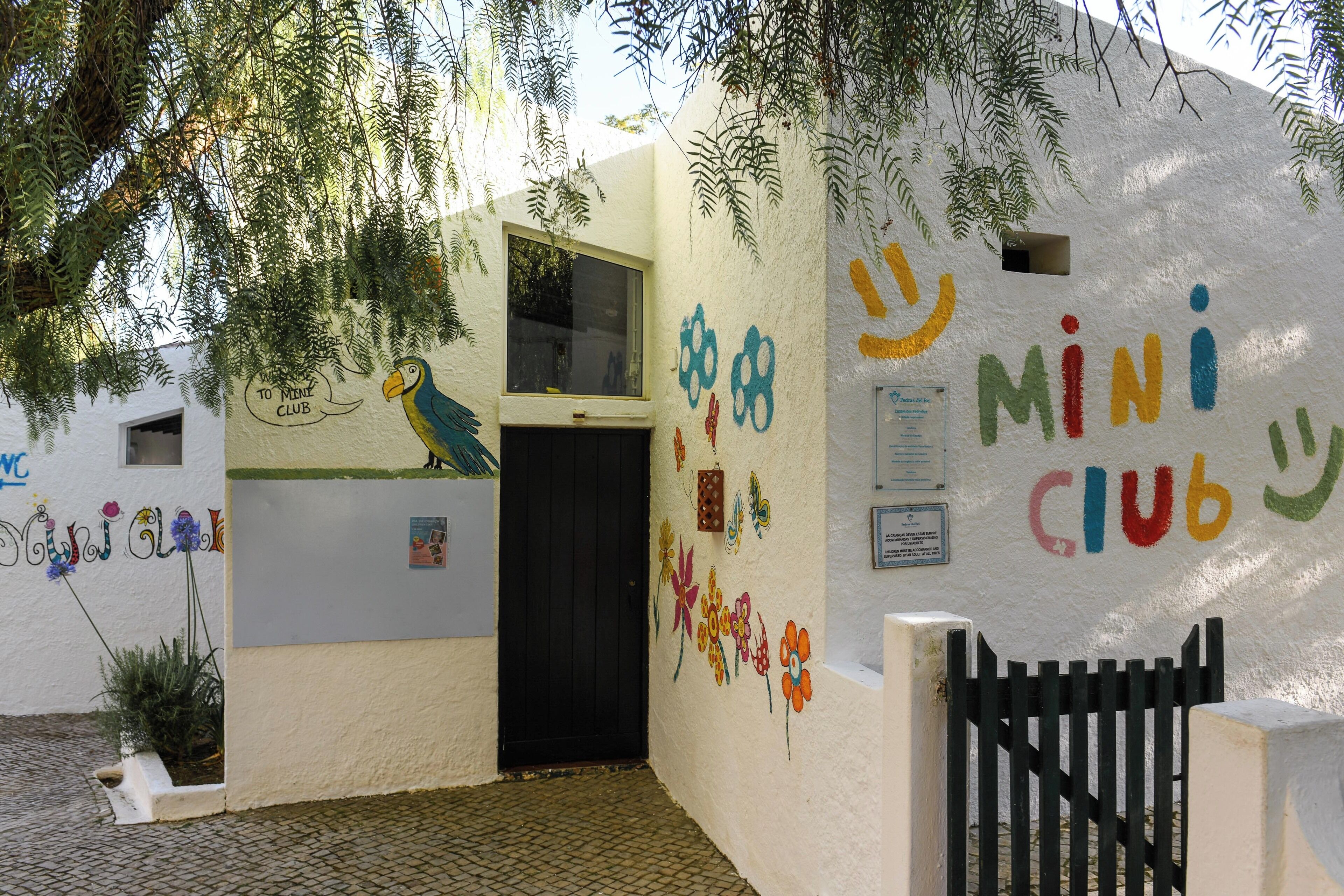 A building with colorful graffiti and a black gate.