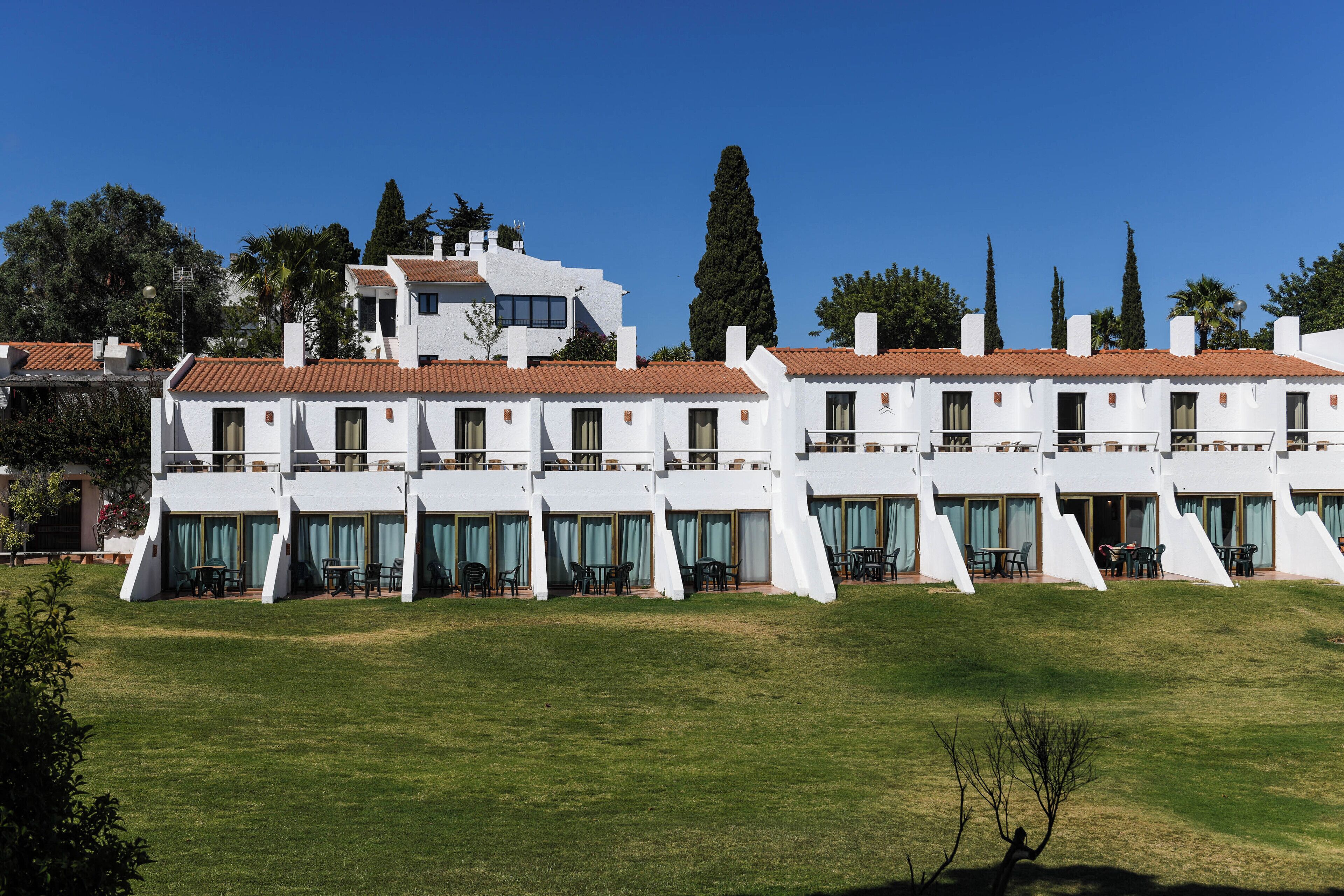 Un edificio blanco con varios balcones y zonas de estar al aire libre.