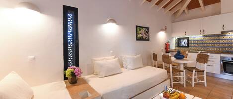 A compact living space with a sofa, dining table, and kitchen area.