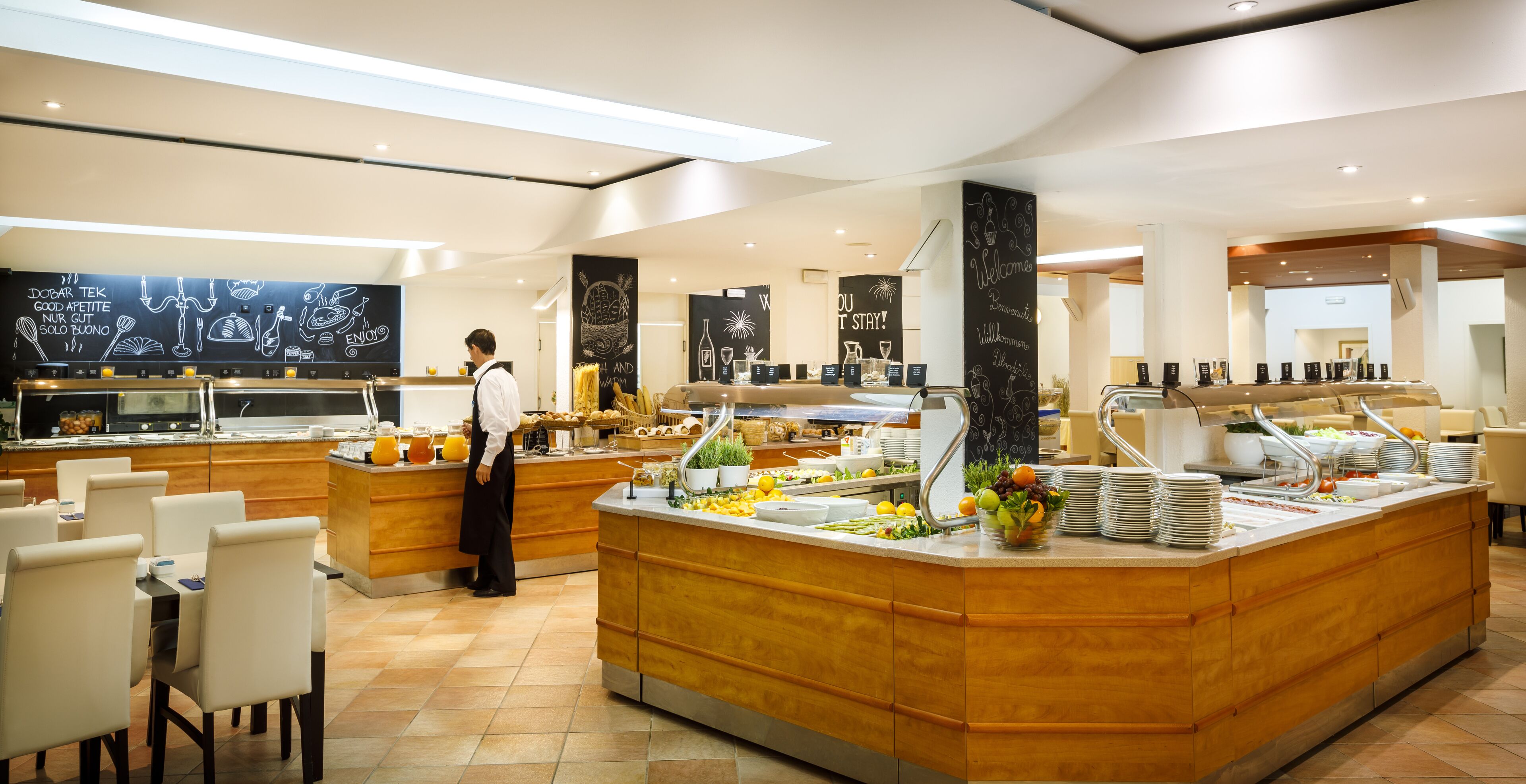 Ein modernes Buffet mit Koch, vielfältigen Speisen und einem hellen, sauberen Essbereich.