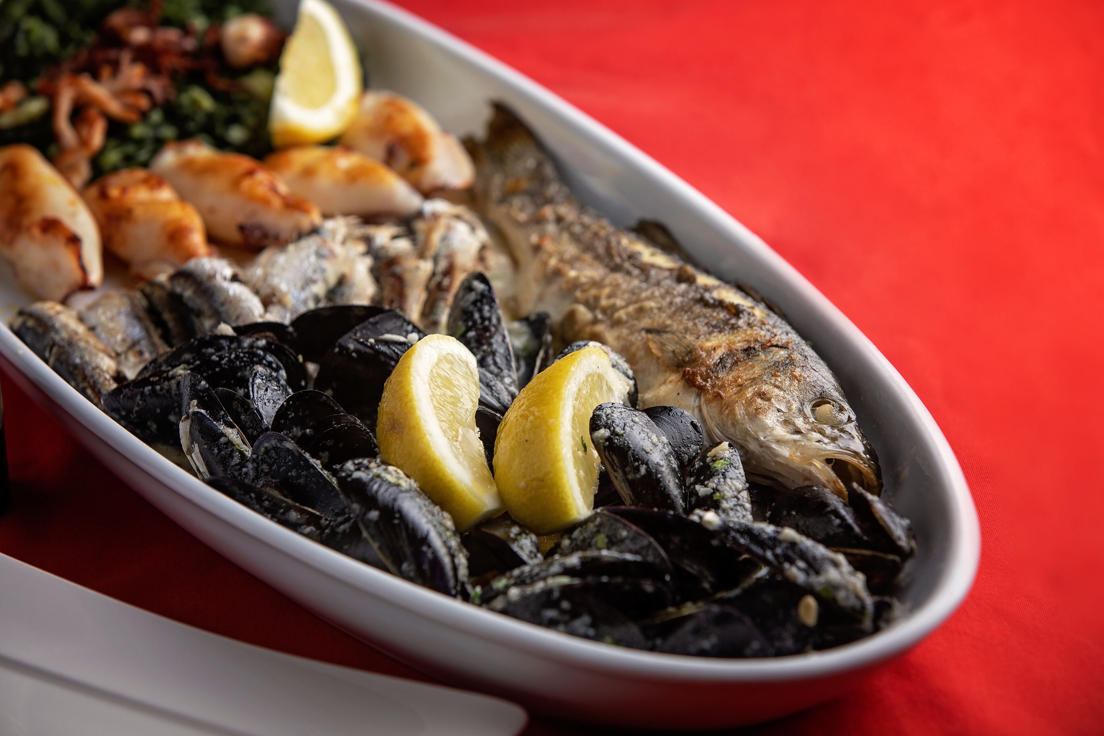 Un plat de musclos, peix i rodanxes de llimona.