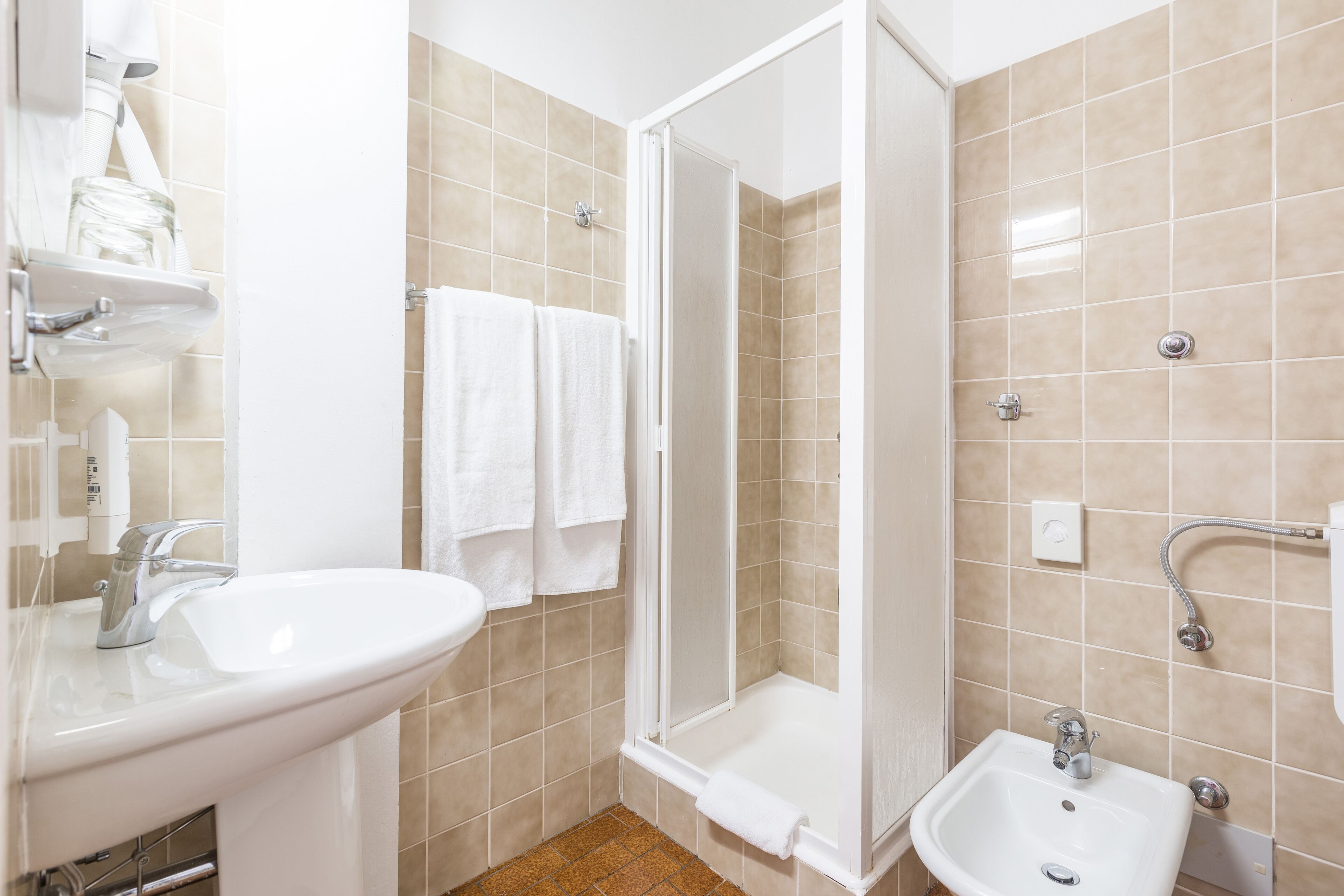 Un baño con lavamanos, ducha y bañera.