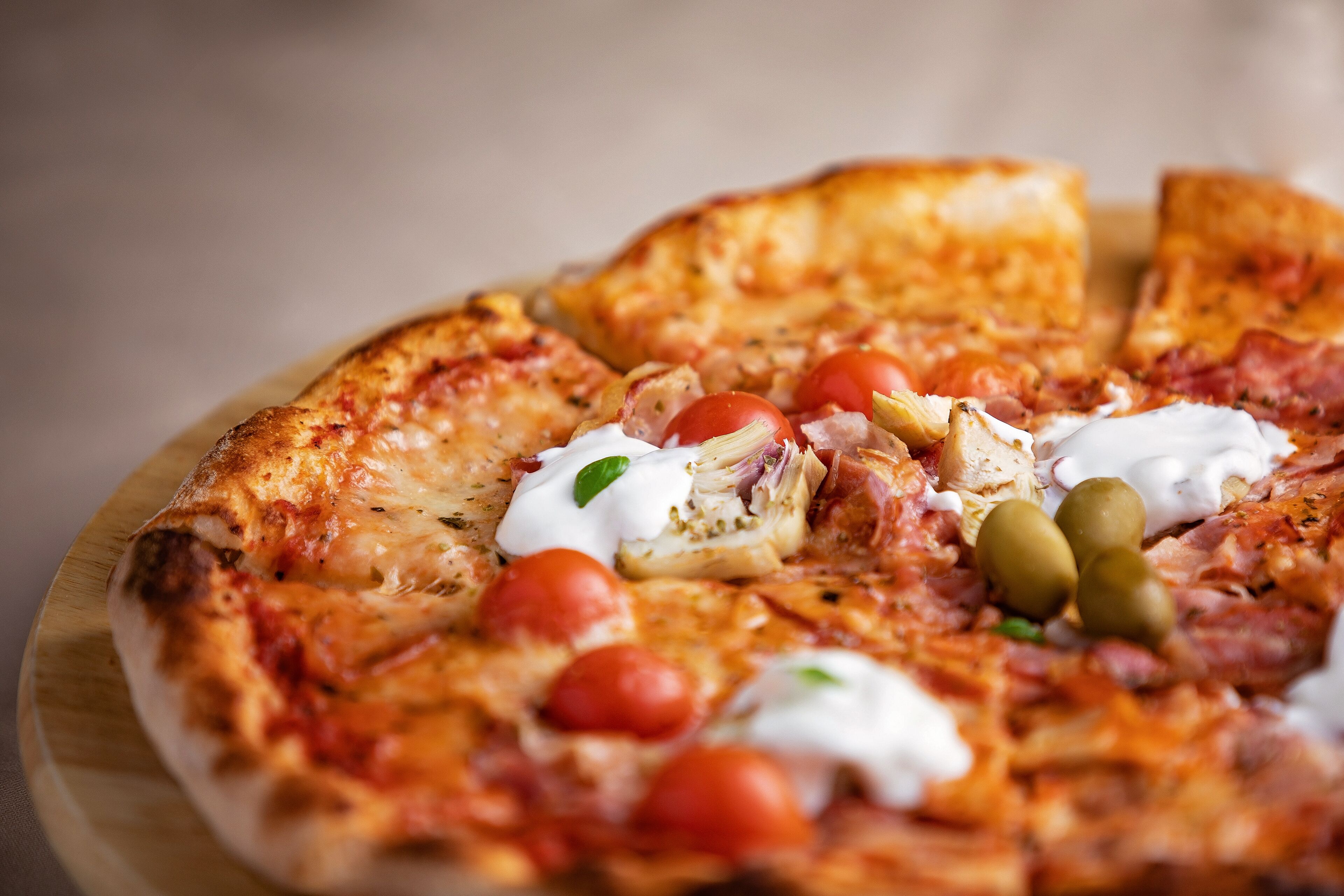 A pizza with various toppings on a wooden board.