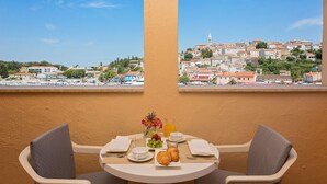 Mesa dispuesta para el desayuno con vistas a un pueblo, edificios e iglesia.