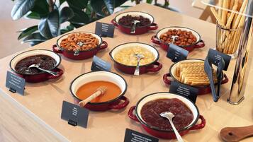 A buffet with various dishes including fruits, nuts, and desserts.