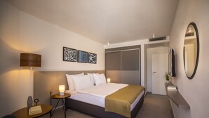 A modern hotel room with a bed, bedside table, lamp, and artwork on the wall. - Maistra Select Funtana All Inclusive Resort (Funtana)