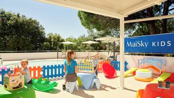 Relax and play in our outdoor play area, featuring a pool, play structures, and seating arrangements.