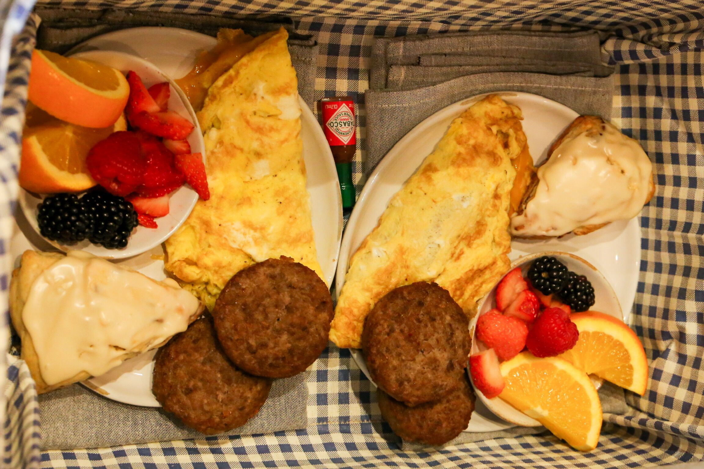 Ein Frühstückswagen mit Pfannkuchen, Würstchen und einer Obstschale mit Erdbeeren, Brombeeren und Orangen.