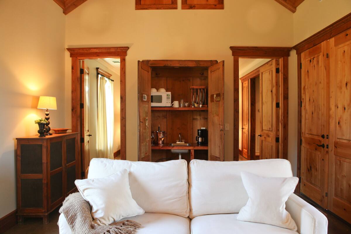 A cozy room with a white sofa, wooden cabinets, and a lamp.