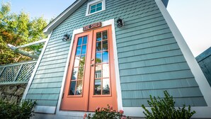 A building with a sign reading "THE SHED" above a door, surrounded by greenery. - Town & Tide Inn (Newport)