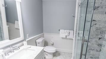 Ein Badezimmer mit Waschbecken, Toilette und Dusche.