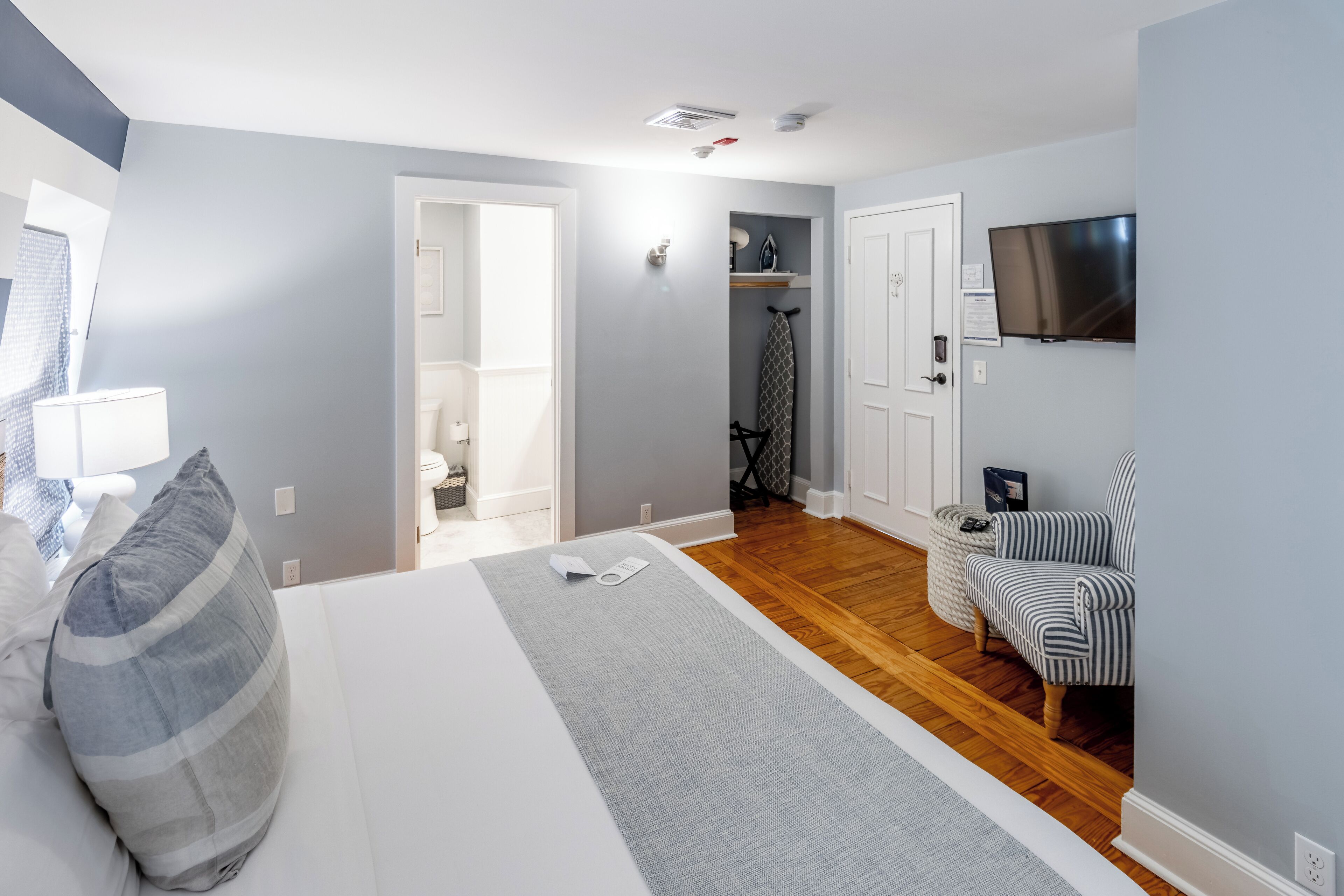 Een hotelkamer met een bed, een televisie, een zithoek en een kledingkast.