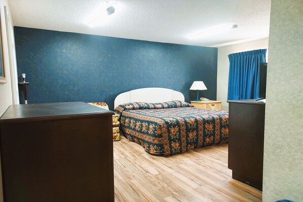 Una habitación de hotel con una cama, un escritorio y un armario.