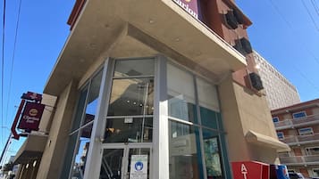 Edificio de Clarion Inn con entrada de vidrio, un cajero automático y un cartel que dice 'Seguridad Primero'.