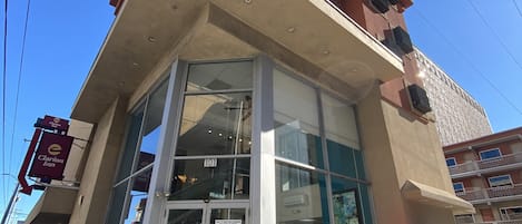 A Clarion Inn building with a glass entrance, an ATM, and a 'Safety First' sign.