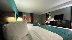 A hotel room with two beds, a desk, a television, and a mirror. - Clarion Inn Atlantic City - Beach and Boardwalk (Atlantic City)