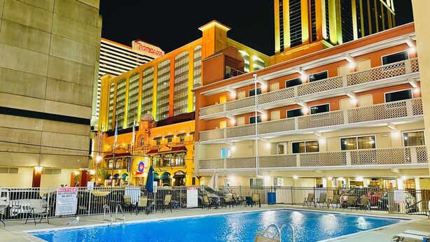 A hotel pool area with a view of Tropicana building, multiple floors, and outdoor seating. - Clarion Inn Atlantic City - Beach and Boardwalk (Atlantic City)