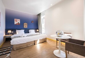A hotel room with a large bed, a small round table, a chair, and a window with curtains. - B&B HOME Brides-Les-Bains Les 3 Vallées (Brides-les-Bains)