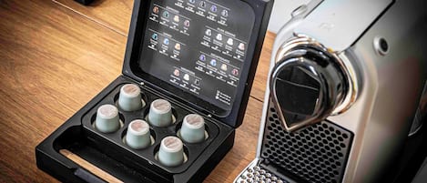 A Nespresso coffee machine with a selection of coffee pods and a remote control.