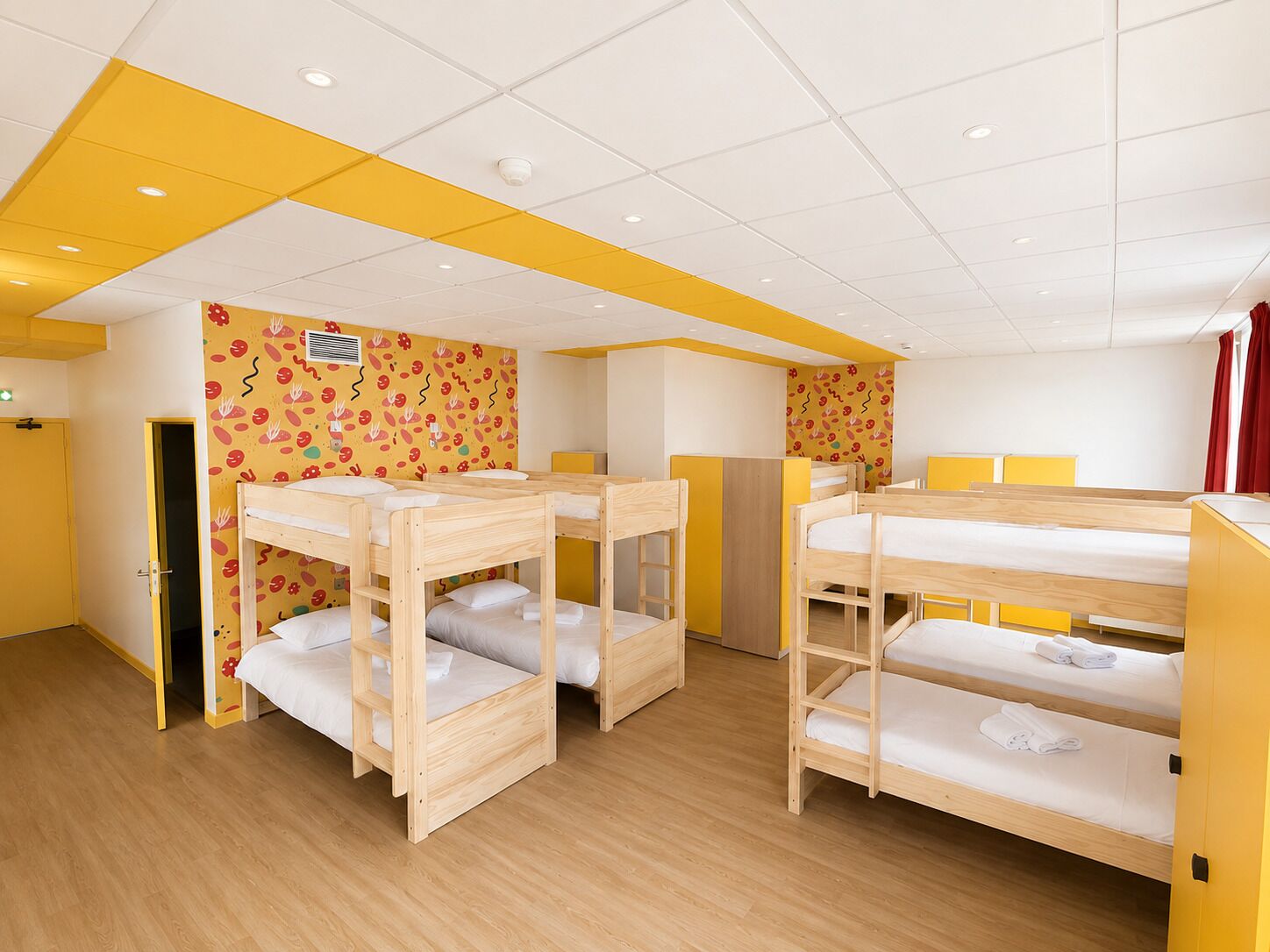 Una habitación infantil con literas, una puerta y un muro con un diseño divertido.