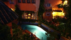 A castle-like building with a swimming pool surrounded by greenery. - Amanhavis Hotel (Benahavis)