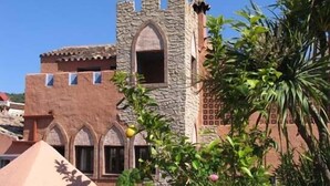 A building with a stone tower, arched windows, and a pyramid-shaped structure. - Amanhavis Hotel (Benahavis)