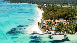 An aerial view of a coastal resort with a beach, clear turquoise waters, and a cluster of buildings with a pool. - SALT of Palmar, an adult-only boutique Hotel (Belle Mare)
