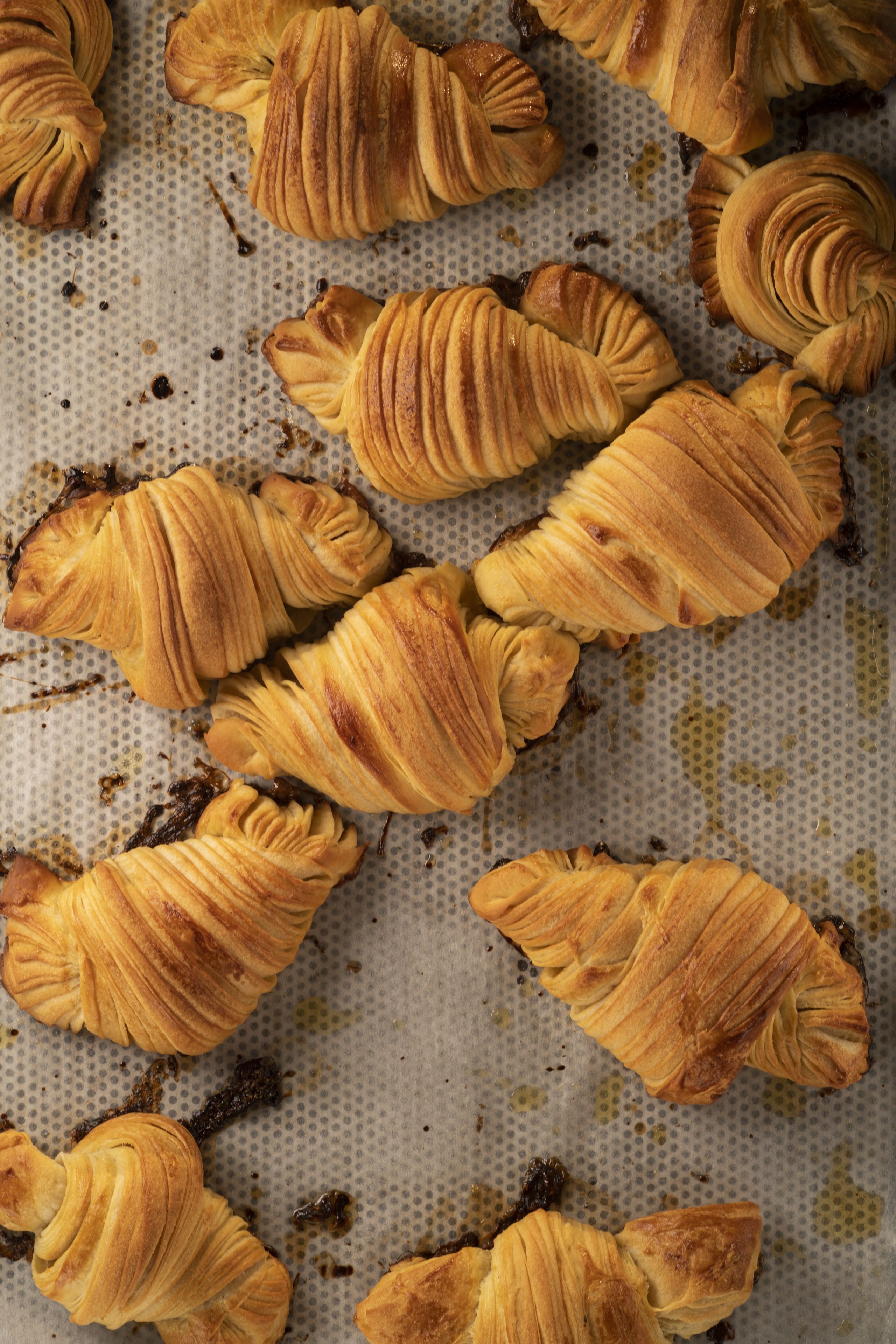 A collection of croissants arranged on a baking sheet.