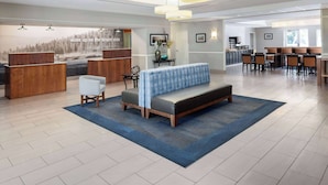 A spacious lobby with a reception desk, seating area, and a view of the outdoors.