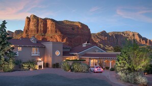 A two-story building with a large rock formation in the background.