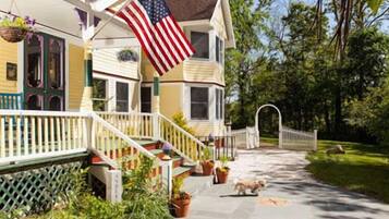 Traditional two-story house with a front porch and well-manicured lawn.