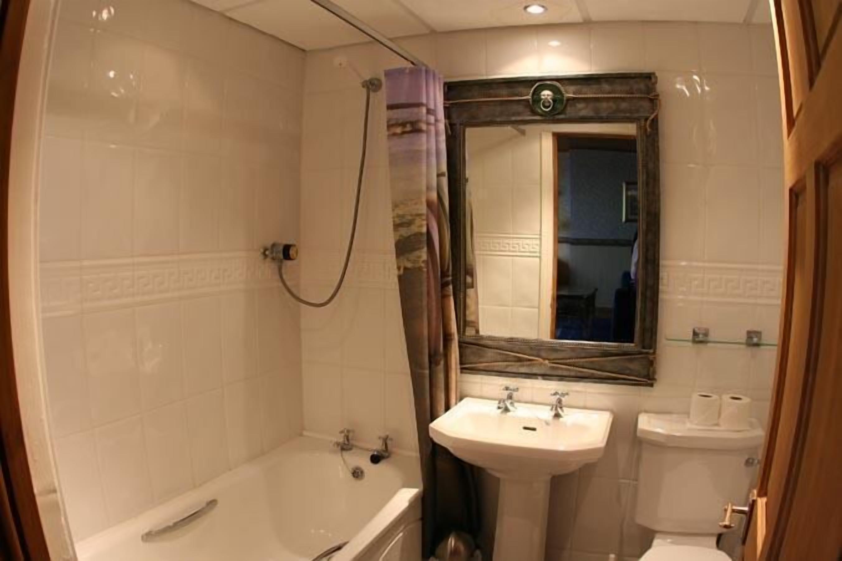 A bathroom with a bathtub, sink, and toilet.