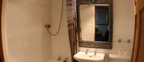 Un baño con bañera, lavamanos e inodoro.