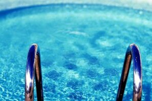 A clear view of a swimming pool with two visible pool ladders.