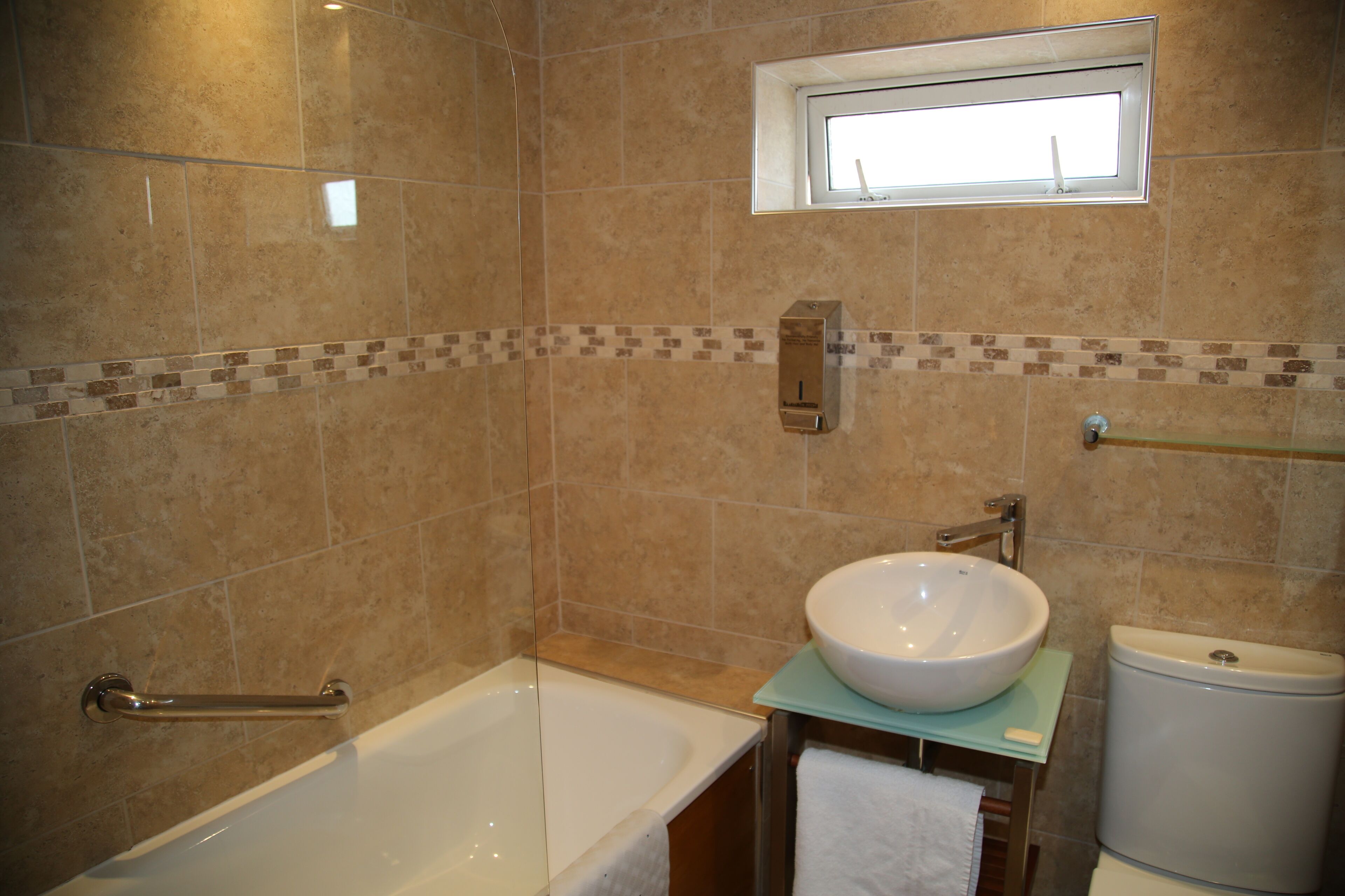 Un baño con bañera, lavamanos e inodoro.