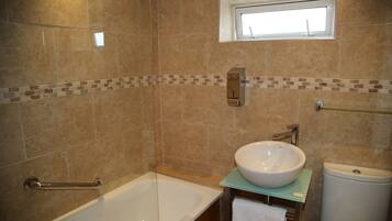 Un baño con bañera, lavamanos e inodoro.